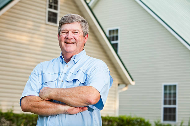 Senior man standing outside home
