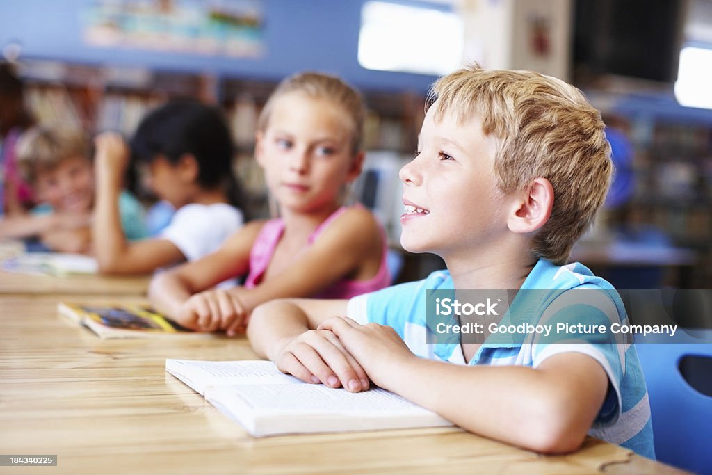 Pensierosa, piccolo ragazzo con gli amici, studiare in biblioteca - Foto stock royalty-free di Abbigliamento casual