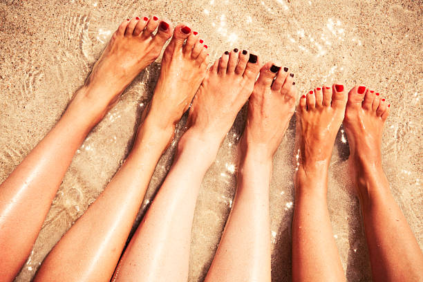 Three girlfriends sitting on the edge of the pool, enjoying in a beautiful summer day
