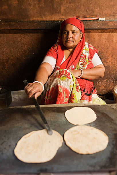 istock Indian woman making chapatti. 184341446