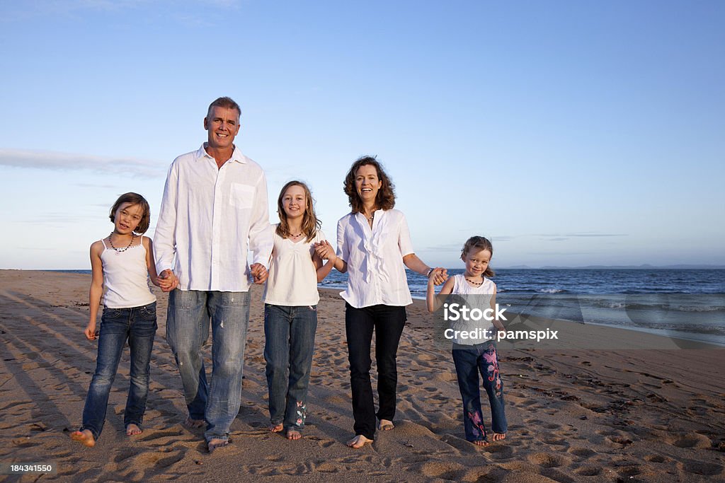 Счастливая семья с тремя детьми на пляже с небесно-голубой - Стоковые фото Белый роялти-фри