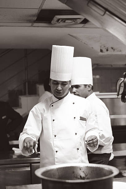 Asian young female cook making meat dish in the kitchen