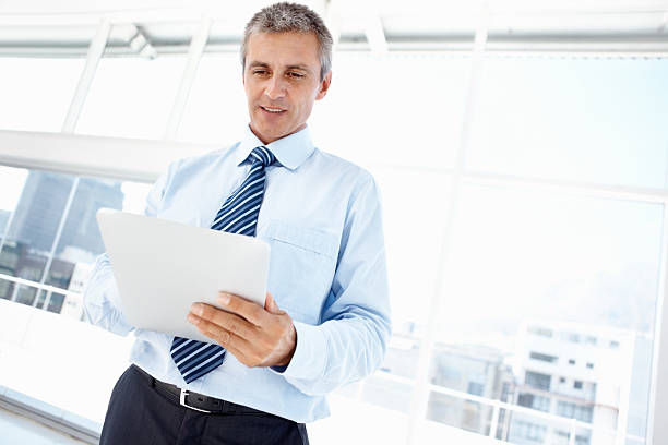 istock Mature business man working on electronic tablet 184341664
