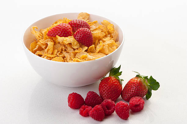 Cornflakes in a bowl with strawberries Cornflakes in a bowl with strawberries and raspberries cornflakes stock pictures, royalty-free photos & images