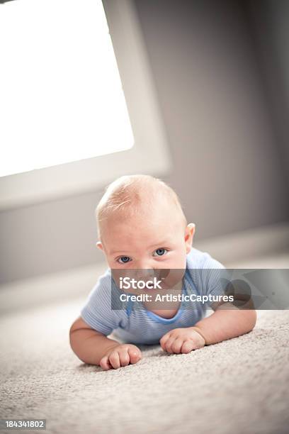 Baby Boy Lying On Carpet En Dormitorio En Su Hogar Lejos Del Hogar Foto de stock y más banco de imágenes de Bebé