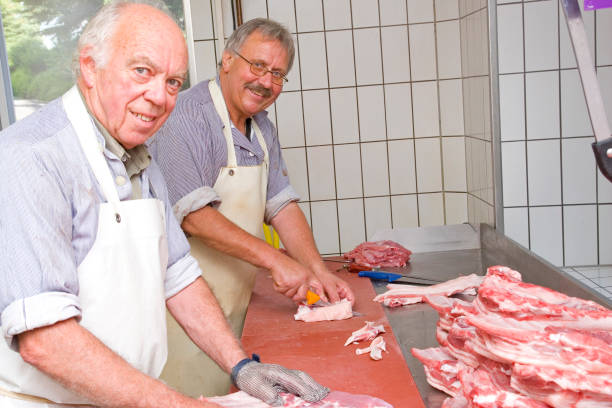 two butchers at work - uitbeenhandschoen stockfoto's en -beelden