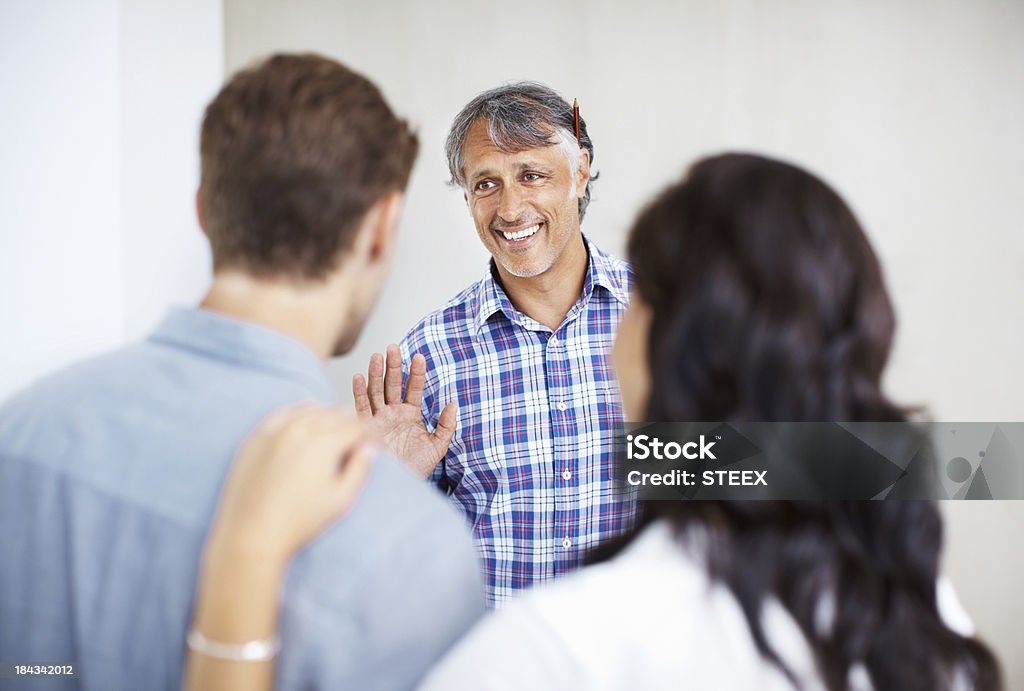 Couple consulting male architect Mature engineer discussing home renovation plan with couple 40-49 Years Stock Photo