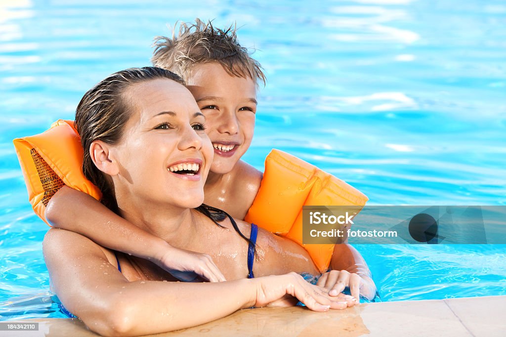 Menino e sua mãe relaxando na piscina - Foto de stock de Piscina royalty-free