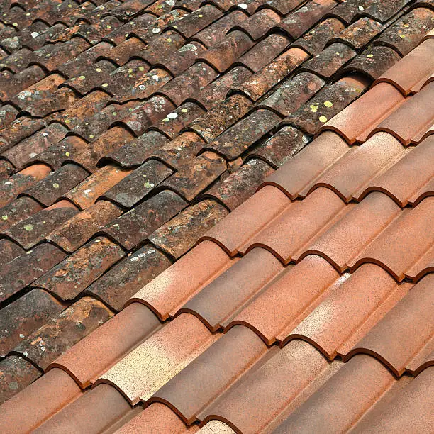 Old and new terracotta rooftiles on a French roof.Similar image: