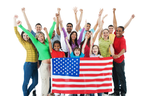 Young group of people with raised hands are holding the American flag and looking at the camera.