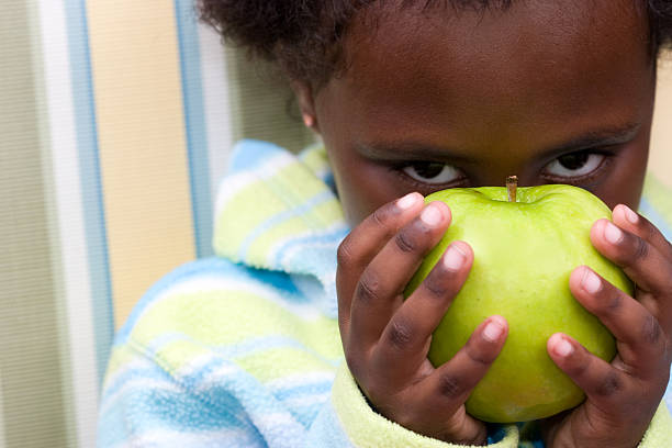 mały piękno przebijają z za jabłka - apple eating little girls green zdjęcia i obrazy z banku zdjęć