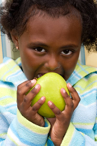 istock Cute girl eating green apple 184342518