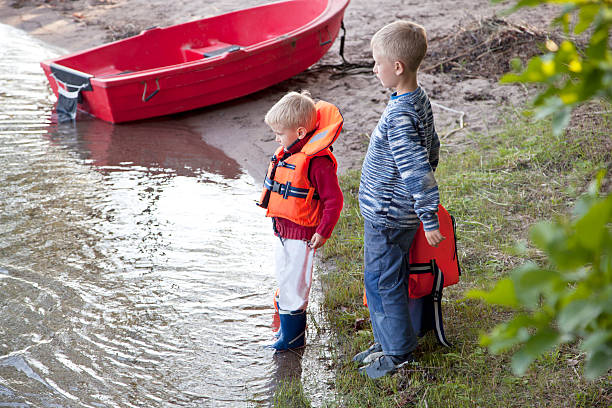 istock Two small boys and a red boat on the beach. 184343084