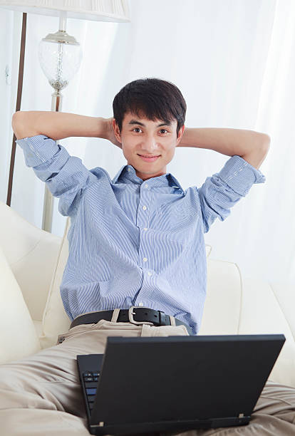 istock smilling businessman sitting on a sofa 184343101