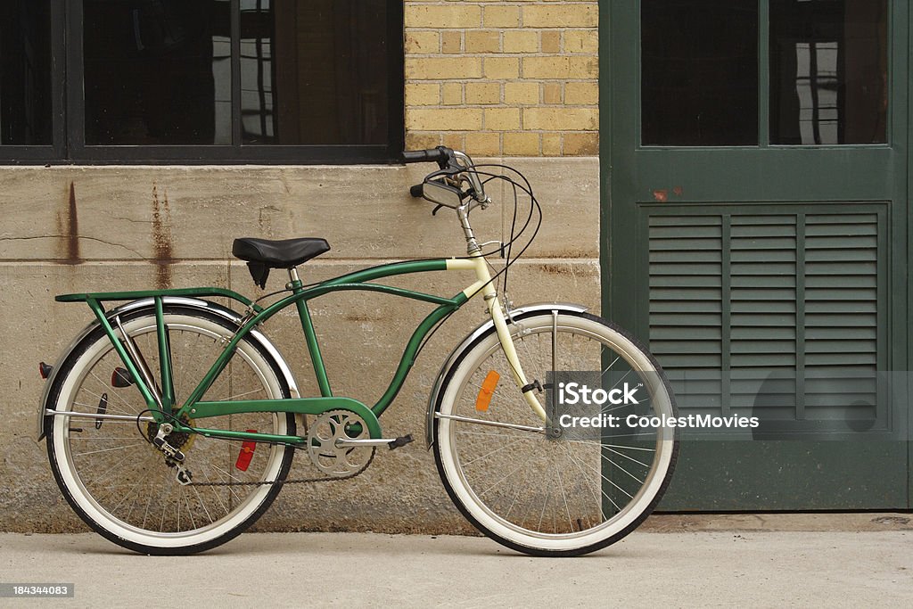 Apoyarse bicicleta Vintage contra la pared de ladrillo, hormigón y verde puerta - Foto de stock de Acero libre de derechos