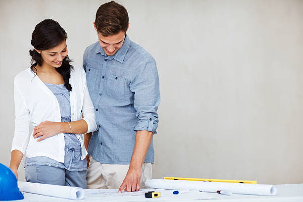 istock Happy couple going over house plan 184344307