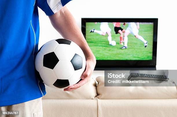 Foto de Assistindo Futebol Na Tv Com Camisa De Futebol E Controle De Bola e mais fotos de stock de Adulto