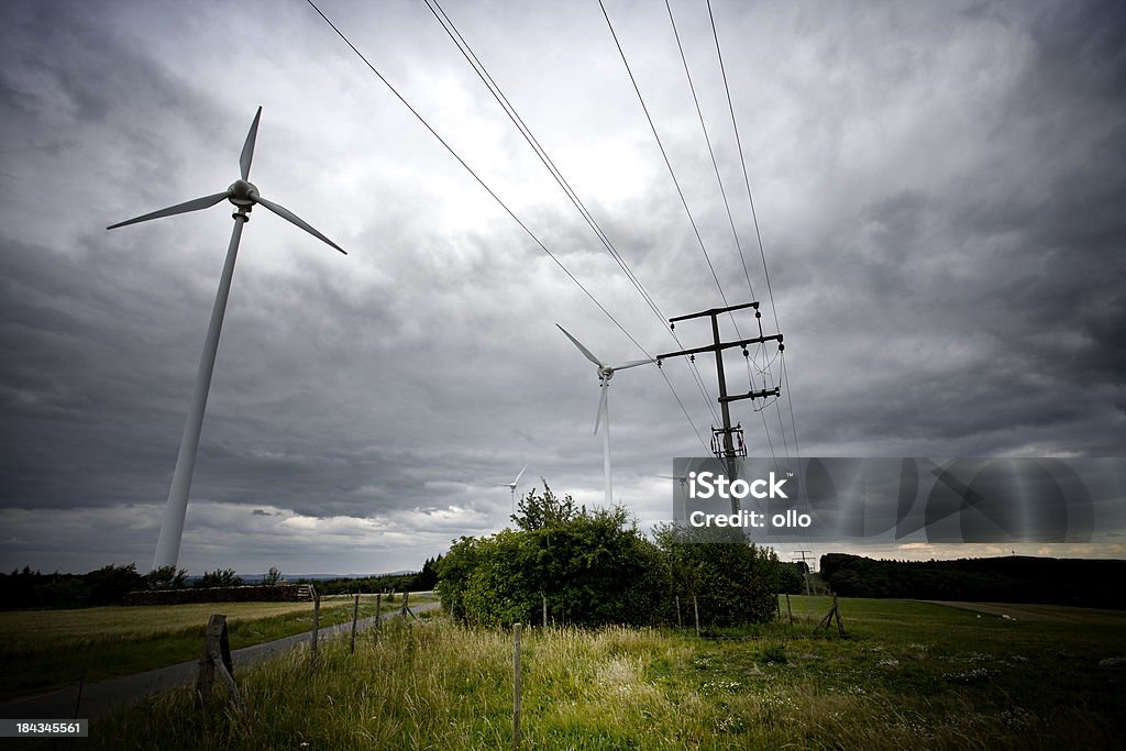 Wind turbines et de Ligne à haute tension, à l'approche Orage - Photo de Alimentation électrique libre de droits