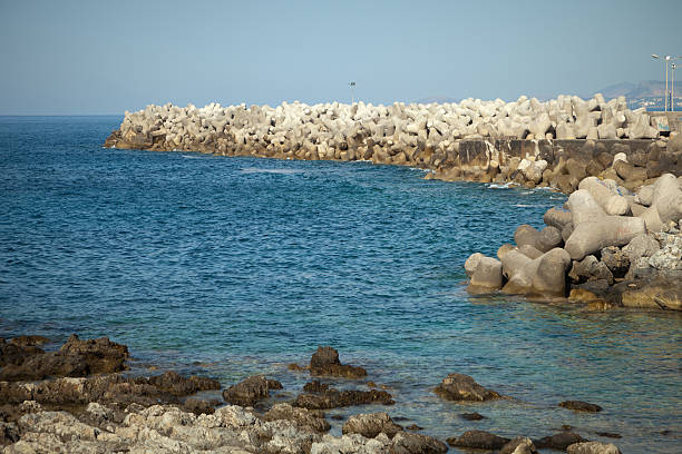 istock Prefabricated concrete breakwater blocks forming a bay 184345645