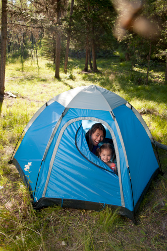 mom and child in tent / they are peeking out the door / they are having fun