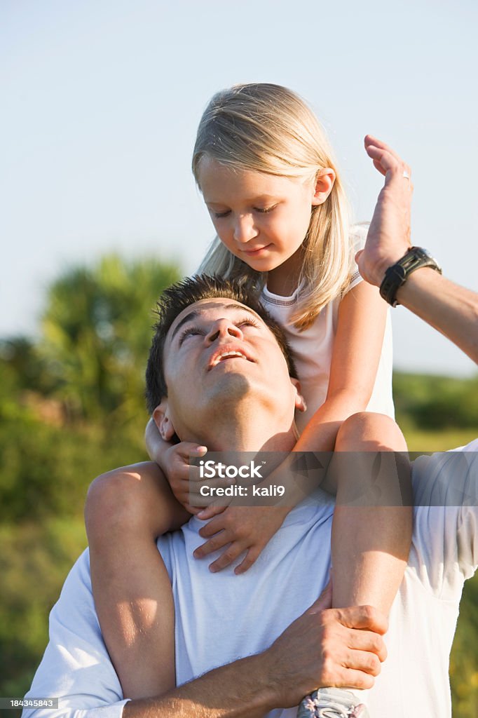 Enfants assis sur les épaules du père en plein air au parc - Photo de 25-29 ans libre de droits