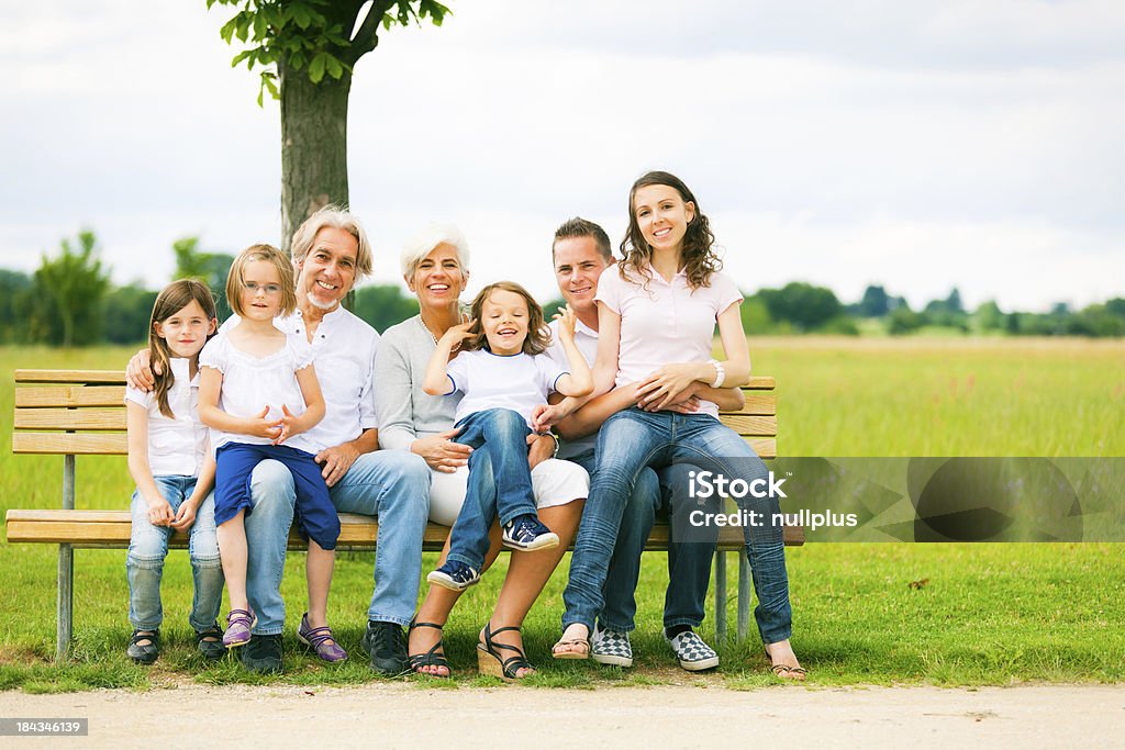 Gran Familia sentada en un banco - Foto de stock de Abuela libre de derechos