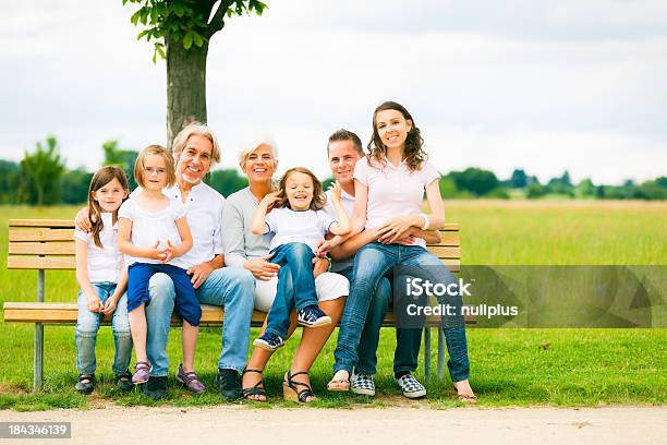Grande Famiglia Seduto Su Una Panca - Fotografie stock e altre immagini di Adulto - Adulto, Allegro, Ambientazione esterna