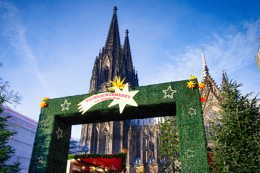 entrance portal to the largest cologne christmas market at the cathedral in daylight with the cathedral in the background
