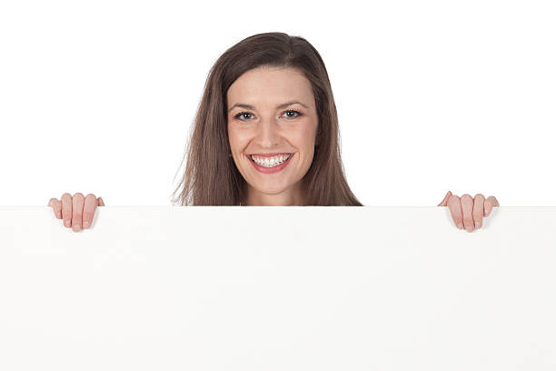 istock Beautiful woman smiling behind a placard 184347003