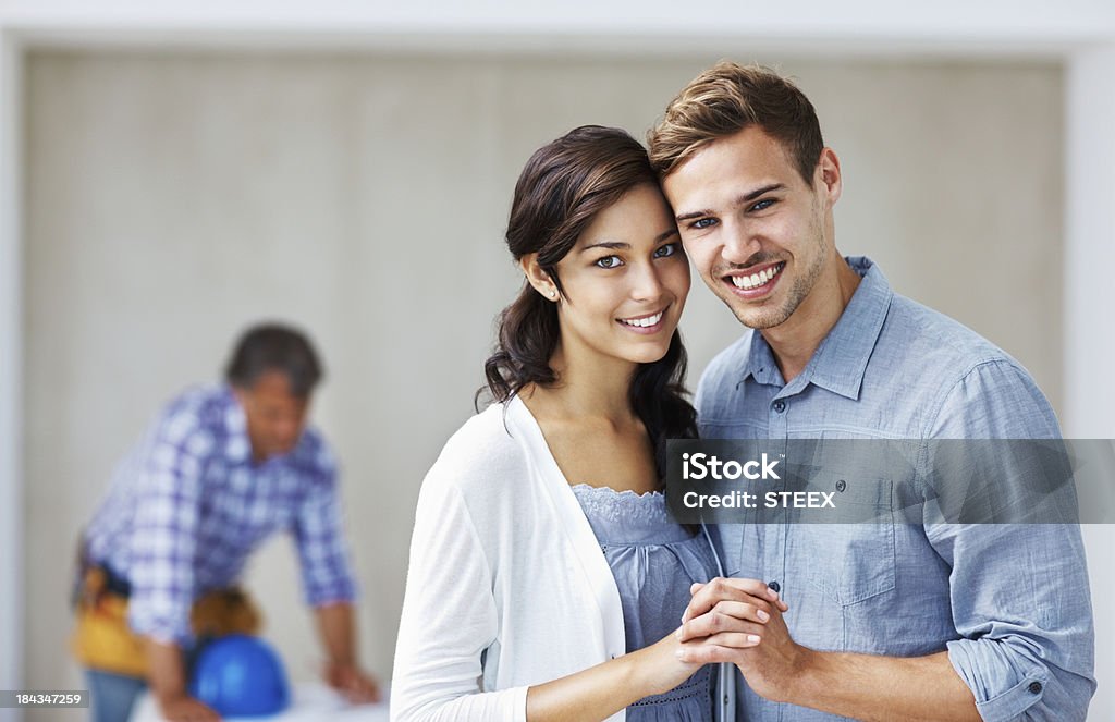 Szczęśliwa para uśmiecha się z architektem w tle - Zbiór zdjęć royalty-free (20-29 lat)