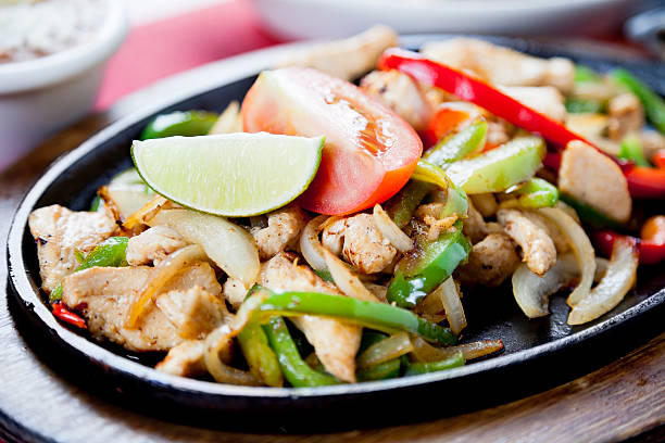 istock Mexican food:  chicken fajitas on a hot cast iron skillet 184347508