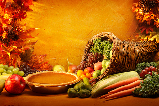 Flat lay frame with colorful autumn leaves and pumpkins on an orange background