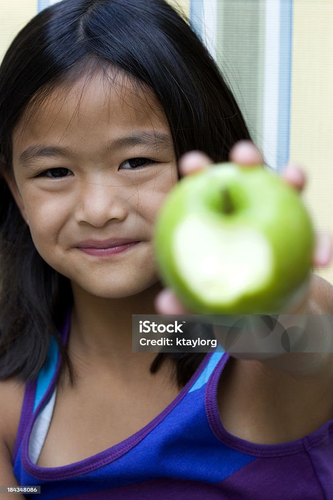 Девушка показывает яблоко с Надкушенный - Стоковые фото 8-9 лет роялти-фри