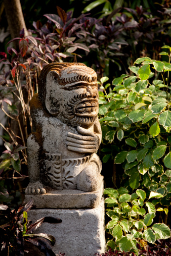A Balinese statue in a garden.