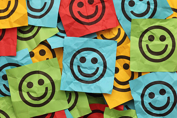 piegato adesivo note con volti sorridenti - sadness depression smiley face happiness foto e immagini stock