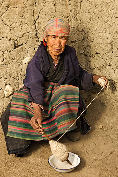 istock Tibetan woman spinnig wool 184349962