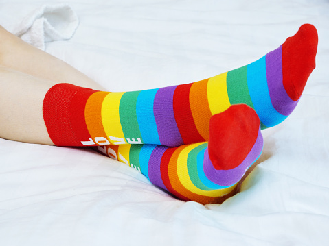 Girl wearing different socks while sitting on sofa at home