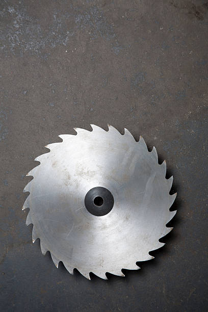 Sawblade A circular saw blade, a little rusty, on a grimy concrete background. rotary blade stock pictures, royalty-free photos & images