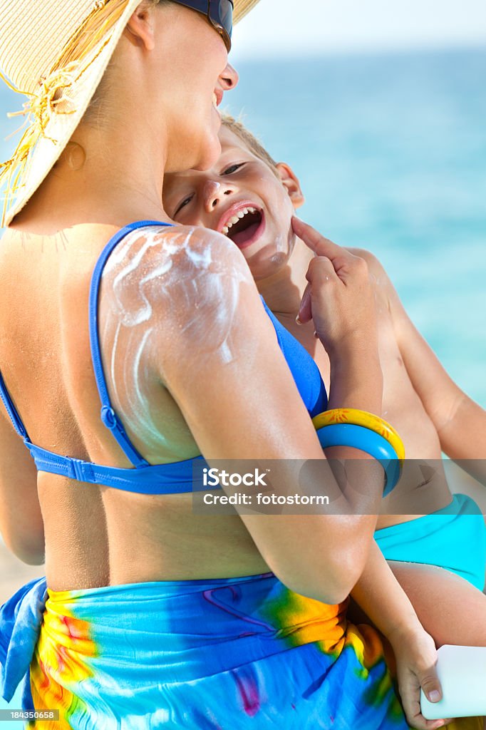 Mulher aplicando protector solar para o seu filho - Royalty-free Abraçar Foto de stock