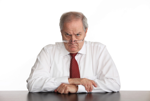 Angry businessman sitting at his desk.