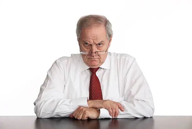 Angry businessman sitting at his desk.