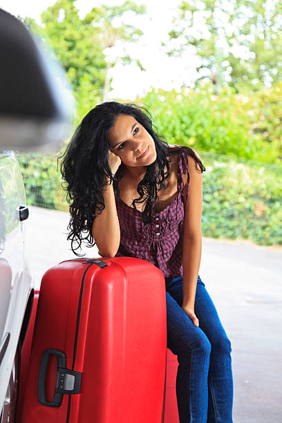 istock Young female going on holiday sitting with suitcases. 184352032