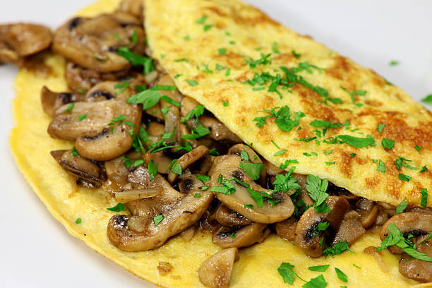 istock Mushroom omelet garnished with parsley on a white plate 184352165
