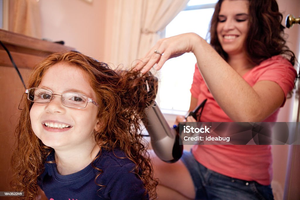 Madre hija de secarse el pelo en el baño en su hogar - Foto de stock de 30-34 años libre de derechos