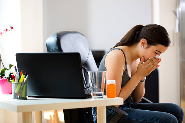 istock Woman Sneezing at Her Desk 184352620