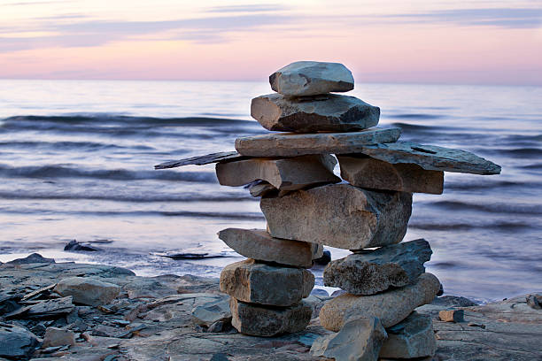 inuksuk at 해질녘까지 - cairn stacking stone rock 뉴스 사진 이미지