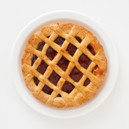 Top view of lattice cherry pie over white dish