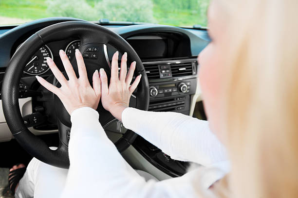 istock Young woman driver pressing in a car horn . 184354095