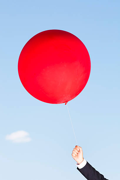 istock Hand holding a red helium balloon 184354788