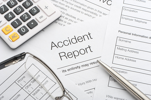 Close up of a accident report with pen and calculator